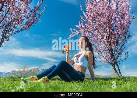 Frau entspannend nach dem Ausführen der Übung Trinkwasser Stockfoto