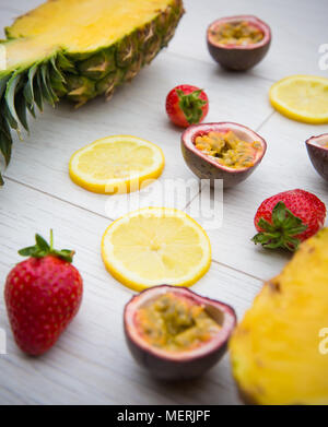 Auf der Suche nach unten von oben auf den frischen Früchten wie Passionsfrucht, Mango, Erdbeeren und Ananas, das sind die Zutaten für einen tropischen Smoothie. Stockfoto