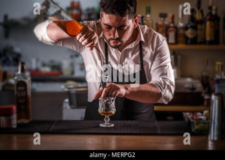 Barkeeper gießen Mischung in eine jigger Cocktail vorbereiten Stockfoto