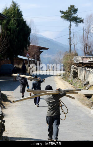 Männer, die aus Bambus und Holzbohlen durch Dorf, Haa Valley, Bhutan Stockfoto