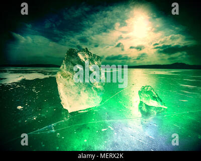 Abstrakte Wirkung. Detail Ansicht in ein Ice auf tiefe Kratzer und Risse. Cut Scholle gegen den Abendhimmel und Suchscheinwerfer. Stockfoto