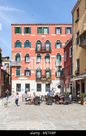 Touristen entspannen im Freien ein Restaurant, Campo de Santa Giustina detto de Barbara, Castello, Venice, Italien und einem jungen Mädchen zu Fuß ein Hund Stockfoto