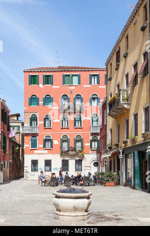 Touristen entspannen im Freien ein Restaurant, Campo de Santa Giustina detto de Barbara, Castello, Venice, Italien mit einer alten Pozzo (Kopf) Stockfoto