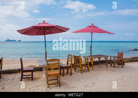 Restaurant am tropischen Strand mit rosa Schirme, Tische Stühle Stockfoto