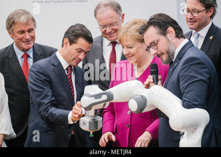 Hannover, Deutschland. 23 April 2018, Deutschland, Hannover: Die deutsche Bundeskanzlerin Angela Merkel, der Christlich Demokratischen Union (CDU, C) und Enrique Peña Nieto, Präsident der Partner Land Mexiko (L), betreiben ein Roboter an der Franka Emika Stand auf der Hannover Messe 2018 (lit. Hannover Messe 2018). Stephan Weil der Sozialdemokratischen Partei (SPD) und Andreas Scheuer der Christlich Sozialen Union (CSU), Bundesminister für Verkehr und digitale Infrastruktur, stehen im Hintergrund. Sami Haddadin des Instituts für Regelungstechnik der Leibniz Universität Hannover steht auf der rechten Seite. Foto: Ole Stockfoto