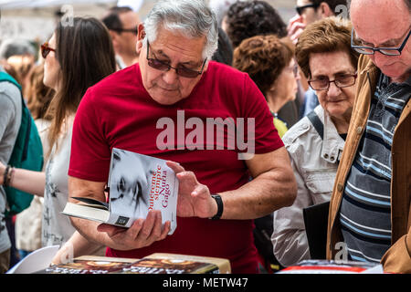 Barcelona, Katalonien, Spanien. 23 Apr, 2018. Ein Mann wird gesehen an Bücher, die in den Ständen der Ramblas suchen. Catalunya die ''Day von Sant Jordi'', der Tag der Bücher und Rosen feiert. Catalunya hofft zu erreichen, die Zahl von 7 Millionen Rosen verkauft. Es ist Tradition eine Rose oder ein Buch bei Liebhabern zu geben. Zahlreiche literarische Autoren signieren ihre Bücher der Öffentlichkeit auf die Straße. Credit: ZUMA Press, Inc./Alamy leben Nachrichten Stockfoto