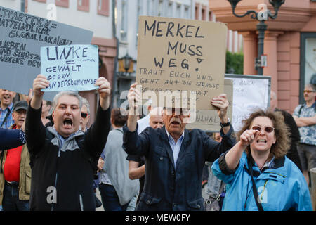 Mainz, Deutschland. 23. April 2018. Rechtsextreme Demonstranten halten Schilder und Shout Slogans in Richtung gegen den Protest. Rund 50 Rechtsextreme Demonstranten sammelten sich in der Innenstadt von Mainz, gegen die deutsche Regierung zu protestieren, für die Schließung der Grenzen und gegen Flüchtlinge unter dem Motto 'MErkel hat zu gehen'. Sie waren gehechelt, um rund 350 Zähler - Demonstranten. Quelle: Michael Debets/Alamy leben Nachrichten Stockfoto