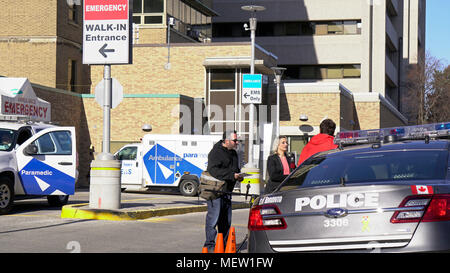 Toronto, Kanada. 23 Apr, 2018. CBC-Reporter versucht, einen Polizisten außerhalb Krankenwagen Notfall Eingang des Sunnybrook Hospital, wo 10 Alex Minassian van Angriff Opfer empfangen werden medizinische Betreuung am Nachmittag des 23. April 2018 zu interviewen. Credit: CharlineXia/Alamy leben Nachrichten Stockfoto