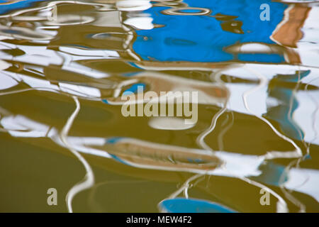 Reflexionen von einem Boot in einer Marina im Wasser des Hafenbeckens festgemacht Stockfoto