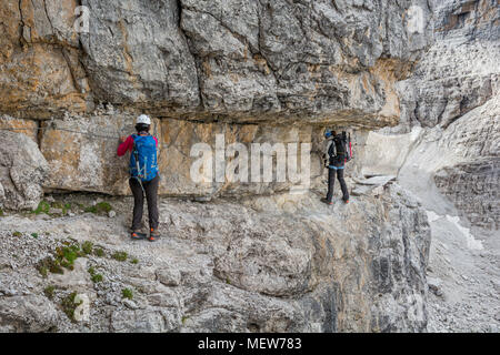 Bergsteiger Wandern auf schmalen Felsvorsprung geschützt durch die Via Ferrata Set. Stockfoto