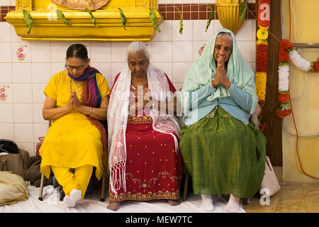 Drei hinduistischen Frauen beten und meditieren in der Shri Lakshmi Narayan Mandir Hindutempel in Richmond Hill, Queens, New York. Stockfoto