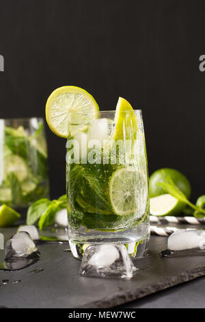 Mojito Cocktail mit garnishin Glas auf Schwarz. Low Key Foto. Close Up. Kopieren Sie Platz. Stockfoto