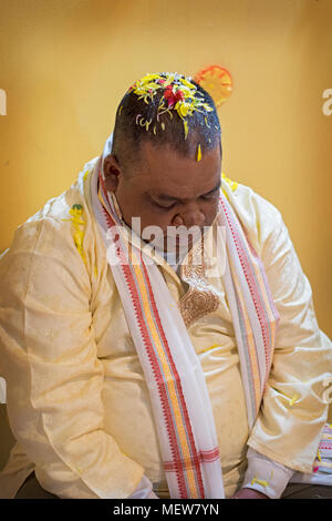 Ein Hindu Anbeter mit Blumen auf dem Kopf als Teil einer Geburtstag Ritual im Shri Lakshmi Narayan Mandir Hindutempel in Richmond Hill, Queens, Stockfoto