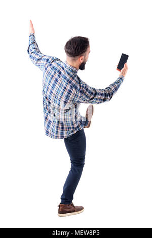 Junger Mann mit Handy lesen Nachricht auf Leerer Bildschirm nach hinten Fallen aufgeregt. Ansicht von hinten. Voller Körper isoliert auf weißem Hintergrund. Stockfoto