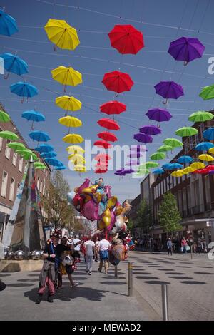 Ballon Verkäufer auf Exeter High Street mit der Exeter Rätsel Obelisk Skulptur und farbenfrohen Frühling Sonnenschirme. Devon, UK. April, 2018. Stockfoto