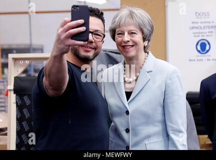 Premierminister Theresa May stellt für eine selfie mit polsterer Derek Whitehouse bei einem Besuch in Boss Design in Dudley als Teil der lokalen Wahlkampf in der Konservativen Partei. Stockfoto