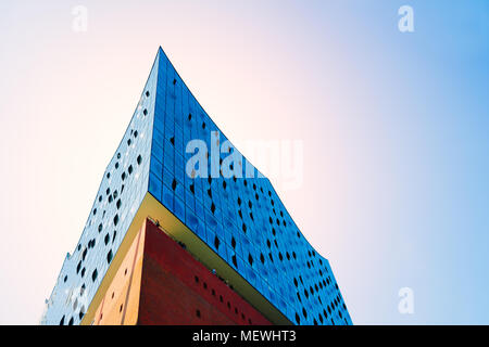 Hamburg, Deutschland - 17. Mai 2018: Die Ecke oder Kante der Elbphilharmonie. Weitwinkel - strahlend blauen Himmel und Sonne Licht mit Flares über rotes Backsteingebäude mit blauen Fenstern Fassade, Hamburg, Deutschland Stockfoto