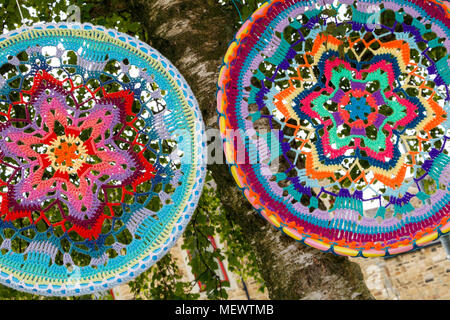 Gestrickte Mandala, die buddhistische Darstellung der Ganzheit oder Universalität zu hängen von den Bäumen an Yarndale, Skipton, North Yorkshire, UK. Stockfoto