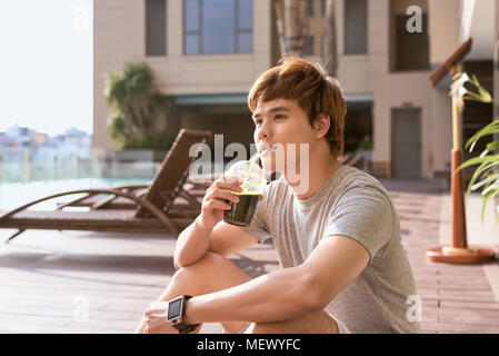 Fitness asiatischer Mann trinken Gemüse Detox-smoothie nach dem Workout. Stockfoto