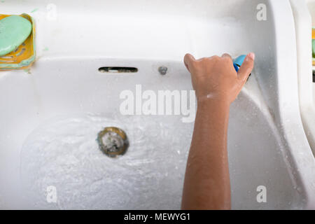Die Mädchen waschen ihre Hände mit grüner Seife auf der linken Seite und war durch das Ausschalten der Wasser Stockfoto