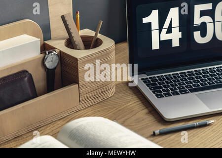 Nahaufnahme der hölzernen Schreibtisch Organizer mit Bleistift und schauen, Computer, Pen und Buch liegen auf dem Schreibtisch Stockfoto