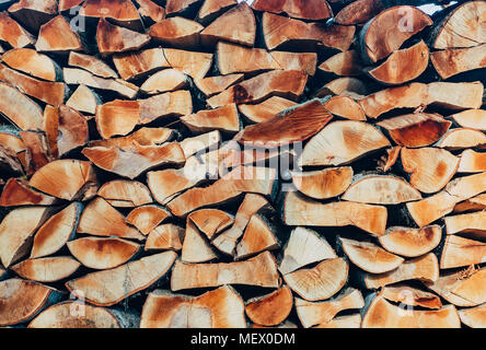 Das zerkleinerte Holz wird in einem Woodpile verpackt. Brennholz auf der jeweils anderen in Reihen gestapelt. Holz stovemone Hintergrund. Stapel Holz Stockfoto
