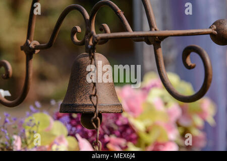 Rusty Bell im Retro Stil hängt an einem alten Metallhalterung Stockfoto