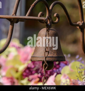 Rusty Bell im Retro Stil hängt an einem alten Metallhalterung Stockfoto