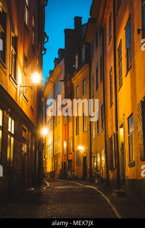 Klassische Dämmerung Blick auf traditionelle Häuser in der schönsten Gasse in der Stockholmer Altstadt Gamla Stan (Altstadt) während der Blauen Stunde in der Dämmerung leuchtet Stockfoto