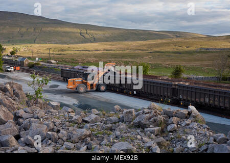 DB Cargo Aggregate Zug mit gritstone in der abstellgleise Geladen neben Ribblehead Station (der alte Steinbruch Ribblehead) Stockfoto