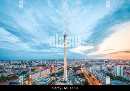 Luftaufnahme der Berliner Skyline mit berühmten Fernsehturm am Alexanderplatz und dramatische Wolkengebilde im Zwielicht während der blauen Stunde in der Abenddämmerung, Deutschland Stockfoto