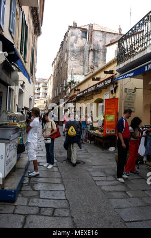 Einem langen schmalen Straße voller Touristen, die sich in der mittelalterlichen Altstadt von Calvi auf Korsika, einer französischen Insel vor der Südküste Frankreichs im Mittelmeer. C Stockfoto