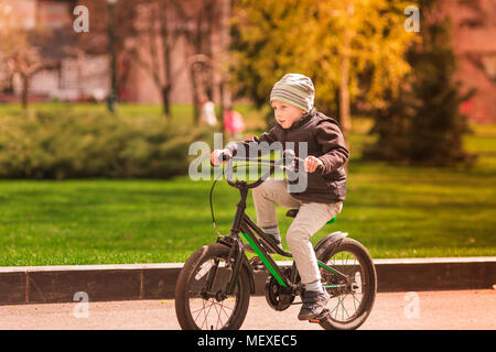 Gerne vier Jahre alten Jungen lernen, wie man ein Fahrrad zu fahren. Erste Reitstunden Stockfoto