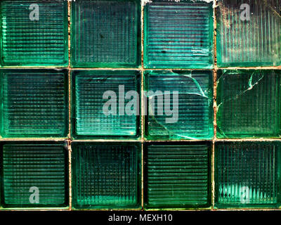 Alte, beschädigte grüne Wand aus grünem Glas Stücke, Hintergrund, Textur, Muster Stockfoto