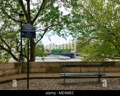 Einsame Bank und touristische Bootsfahrt auf dem Fluss Seine in der Ferne. Place Louis Aragon, Quai de Bourbon, Paris, Frankreich. Stockfoto