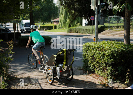 Deutsche Mutter Menschen Biken und Kinder in Kinderwagen gehen Sie zu Hause neben Straße der Stadt Ladenburg am 28. August 2017 in Baden-Württemberg, Deutschland Stockfoto