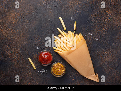 Pommes frites in einer Papiertüte mit Soßen Stockfoto