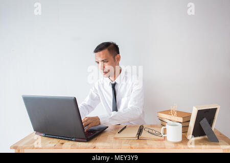 Portrait von Stattlichen asiatische junge Geschäftsmann Arbeiten am Laptop im Büro Schreibtisch Stockfoto