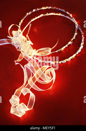 Still life Fotografie der Silbernen Hochzeit Kronen auf rotem Hintergrund - griechische Hochzeit Stockfoto