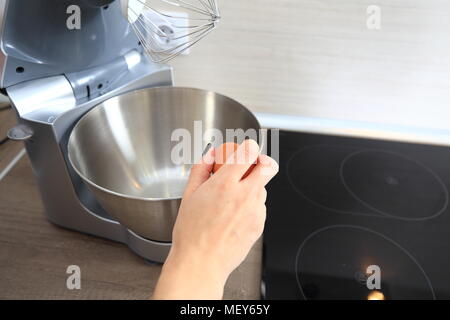 Home Kochen Thema. In der Nähe von Frau hand Hinzufügen Ei in der Küchenmaschine. Stockfoto