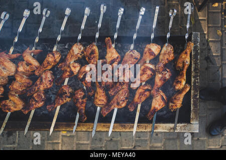 Saftige Scheiben von Fleisch auf Feuer, Hühnchen Shish Kebab. Kebab am Spieß gebraten auf den Grill im Freien. Die Spieße auf dem Grill, Ansicht von oben Stockfoto