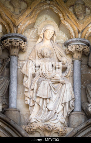 Sculpted Stein Statue der Maria und Jesus auf der Wand über dem Westportal Eingang an der mittelalterlichen Kathedrale der Hl. Jungfrau Maria in Salisbury, England Stockfoto