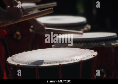 Nahaufnahme von Taiko Drum Felle, geschlagen mit Bachi Sticks. Auf der RAMM Karneval der Tiere, Rougemont Gärten, Exeter, Devon, Großbritannien. April, 2018. Stockfoto