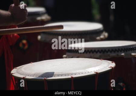 Nahaufnahme von Taiko Drum Felle, geschlagen mit Bachi Sticks. Auf der RAMM Karneval der Tiere, Rougemont Gärten, Exeter, Devon, Großbritannien. April, 2018. Stockfoto