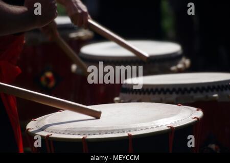 Nahaufnahme von Taiko Drum Felle, geschlagen mit Bachi Sticks. Auf der RAMM Karneval der Tiere, Rougemont Gärten, Exeter, Devon, Großbritannien. April, 2018. Stockfoto