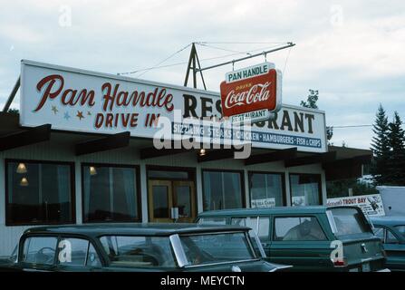 Fassade eines klassischen amerikanischen Drive in Restaurant, die Pan Handle Drive In, mit parkenden Autos außerhalb und ein Zeichen für Coca Cola sichtbar, United States, 1965. () Stockfoto