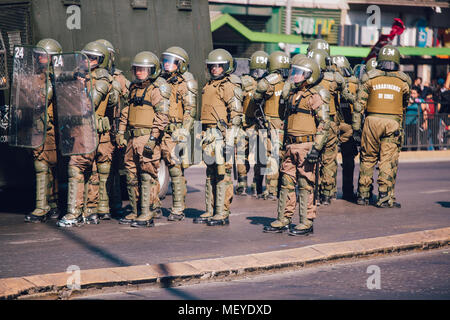 Santiago, Chile - 19. April 2018: eine Linie der chilenischen Polizei beobachten Demonstranten während einer Demonstration in der Innenstadt von Santiago, Chile. Die Demonstranten Stockfoto