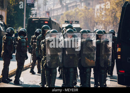 Santiago, Chile - 19. April 2018: eine Linie der chilenischen Polizei beobachten Demonstranten während einer Demonstration in der Innenstadt von Santiago, Chile. Die Demonstranten Stockfoto