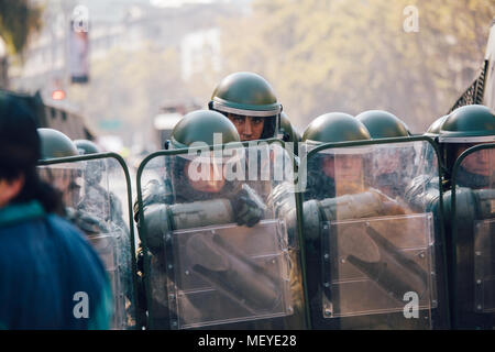 Santiago, Chile - 19. April 2018: eine Linie der chilenischen Polizei beobachten Demonstranten während einer Demonstration in der Innenstadt von Santiago, Chile. Die Demonstranten Stockfoto