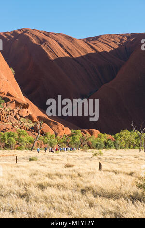 Touristen auf dem Weg zur Mutitjulu Wasserloch des Uluru (Ayers Rock). Uluṟu - Kata Tjuṯa National Park. Northern Territory, Australien Stockfoto